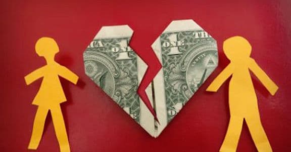 Dollar bill folded into broken heart representing spending issues