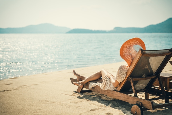 Woman in beach chair meditates on the water.