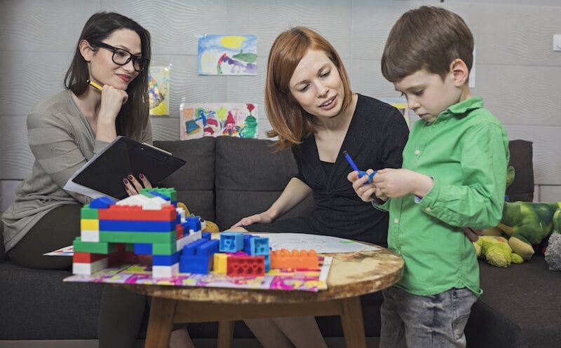 Mother and young child work with therapist using Parent-Child Interaction Therapy PCIT