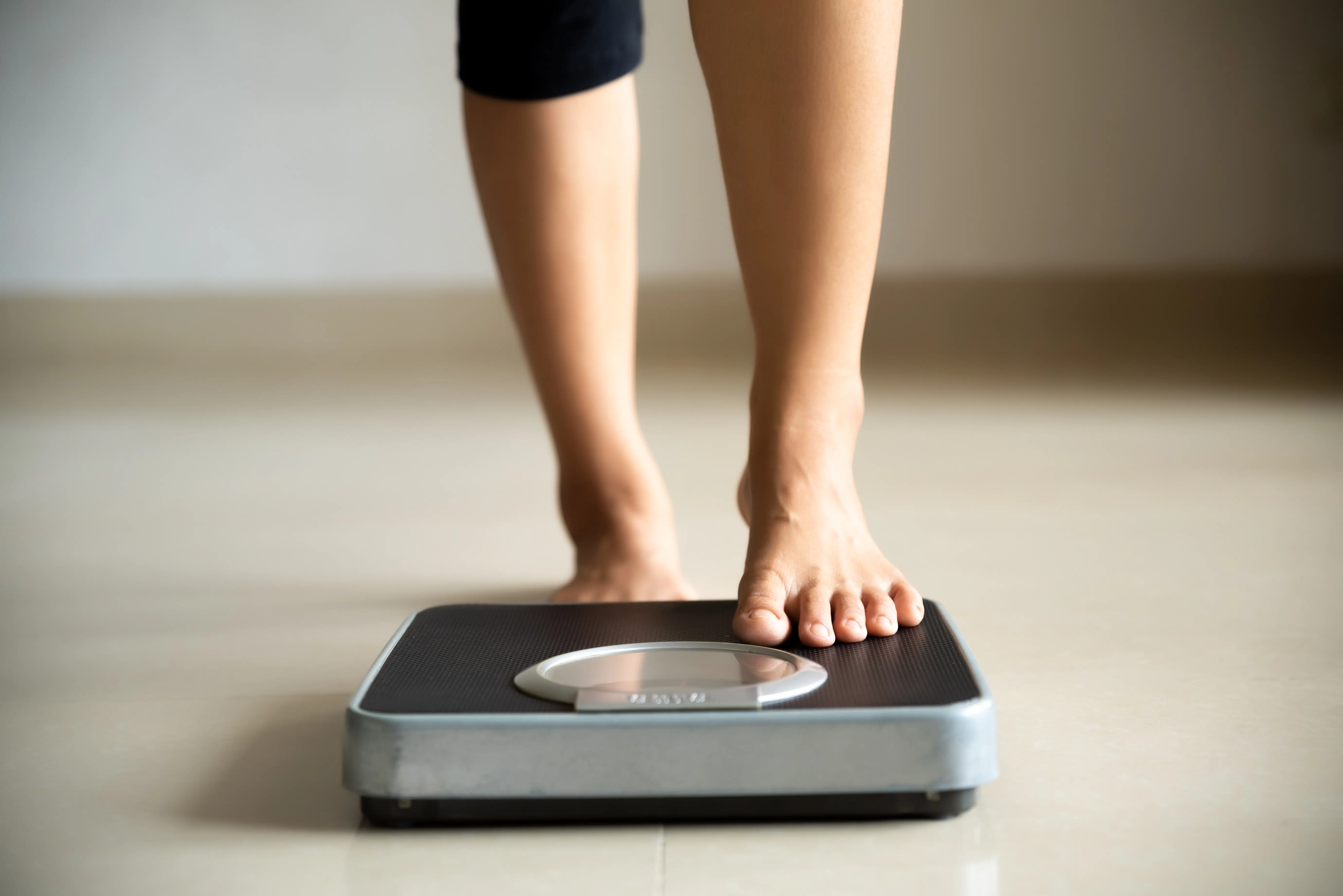 Woman weighs herself on scale