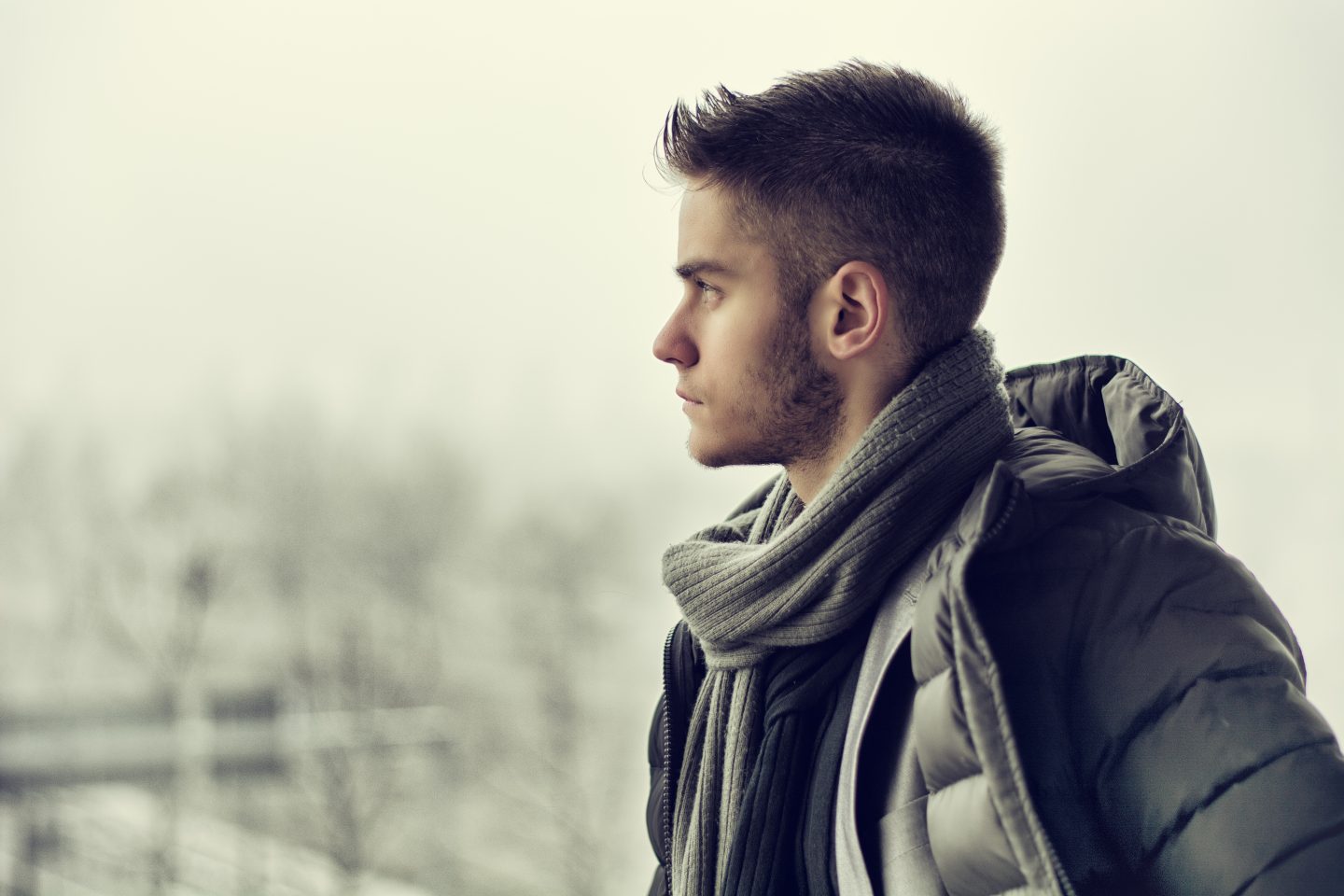 Young man outside on grey, winter day suffering from seasonal affective disorder SAD