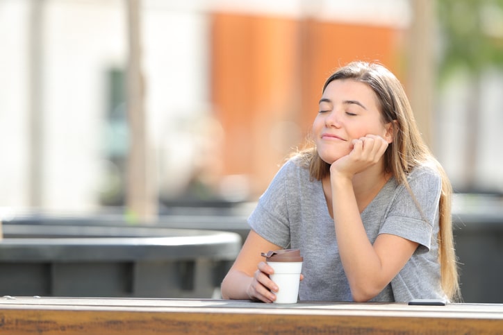 Woman meditates with coffee break in the park