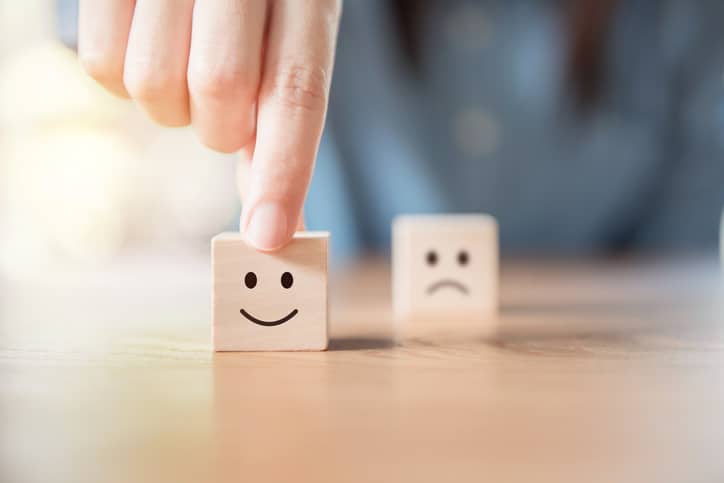 Dice of smiley and sad faces to represent positivity and negativity