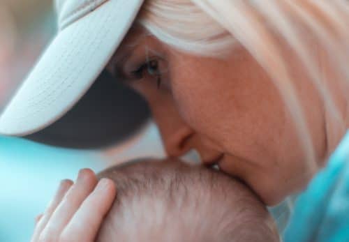 Adoptive mom kisses the head of her baby.