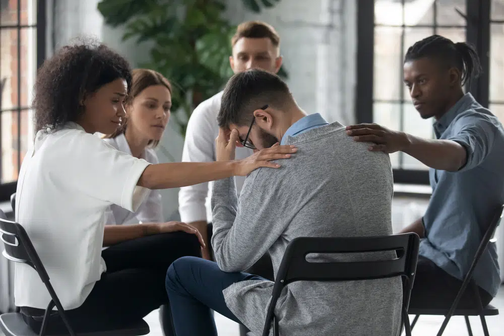 Upset man experiencing anxiety and grief in a support group.