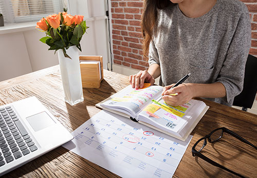 Woman works on calendars at desk
