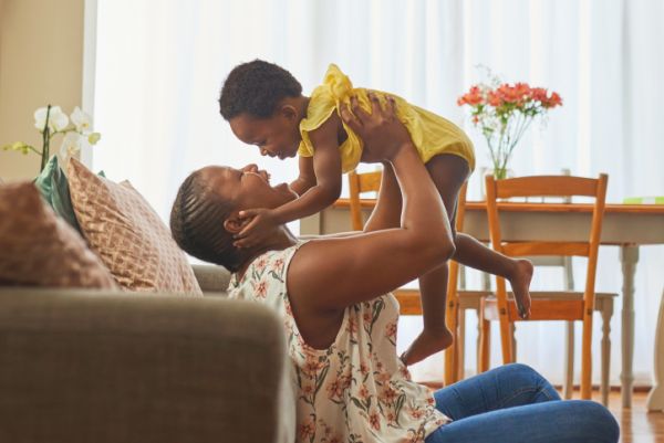 Mom plays with young child.