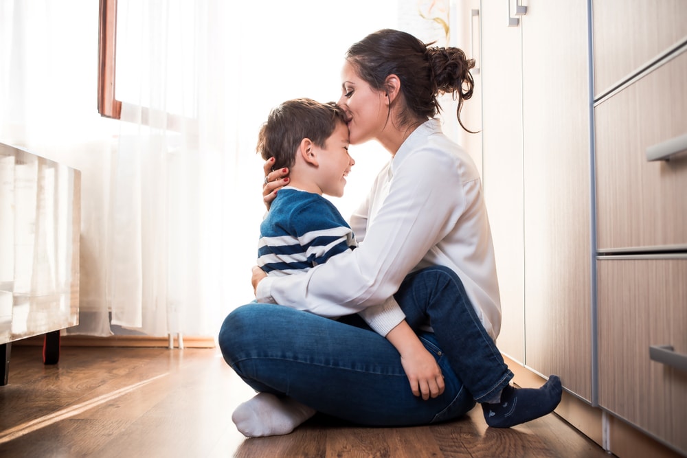 Mother holding her son and hugging him while having parental anxiety