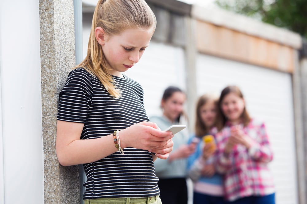 Pre teen girl on phone checking social media