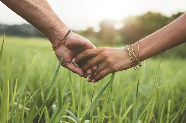 Romantic couple holds hands outdoors