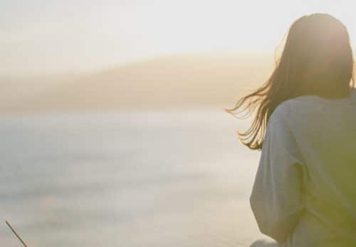 Woman watches the water thinking about life transitions