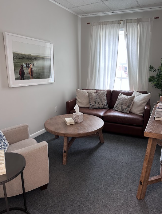 Consultation room with a brown leather loveseat and armchair at the Lukin Center Montclair office