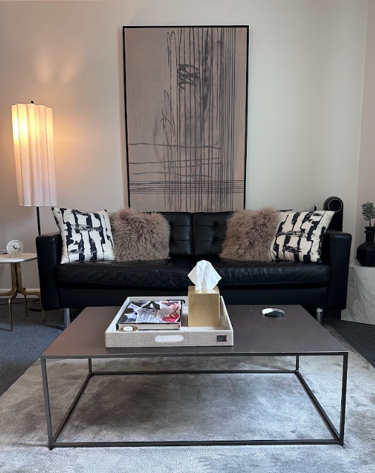Therapy office with a leather sofa and abstract wall art at the Lukin Center Montclair office