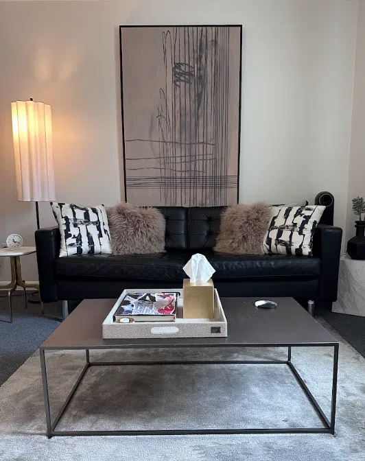 Therapy office with a leather sofa and abstract wall art at the Lukin Center Montclair office
