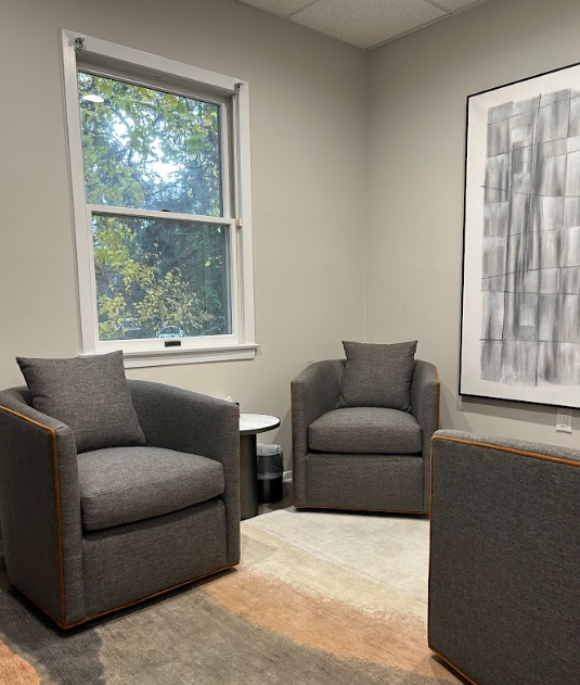 Therapy room with two gray armchairs and abstract art at the Lukin Center Westfield office
