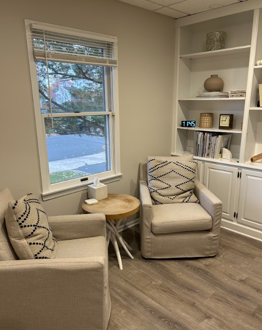 Consultation room with upholstered armchairs and built in shelving at the Lukin Center Westfield office