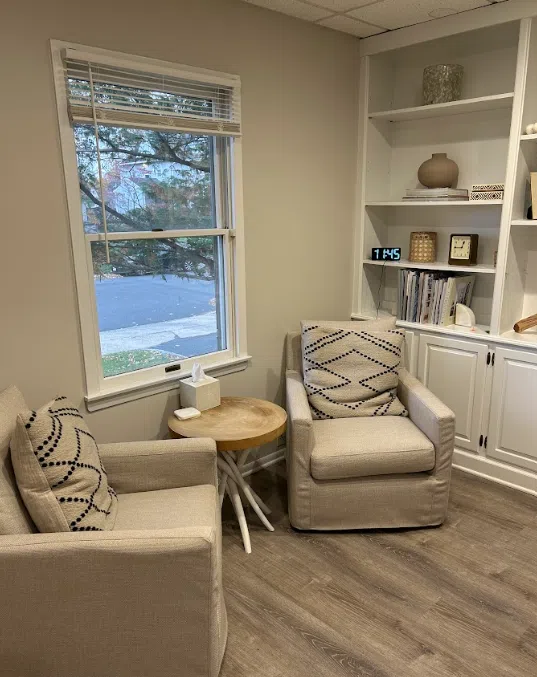 Consultation room with upholstered armchairs and builtin shelving at the Lukin Center Westfield office