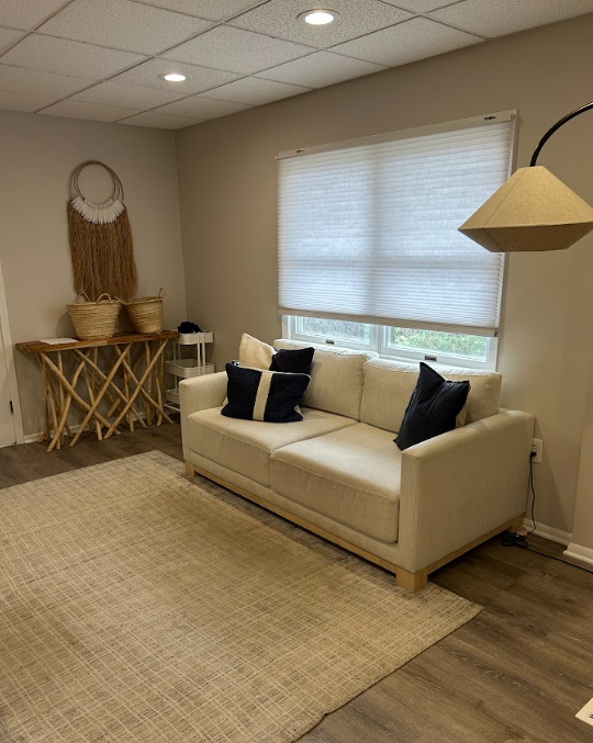 Bright therapy room with a beige sofa and jute rug at the Lukin Center Westfield office