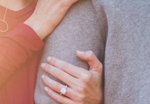 Wife holds husband's arm.