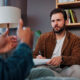 A therapist holding a notepad while speaking with a patient for the topic does insurance cover therapy.