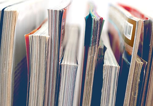 Several publications standing together on shelf