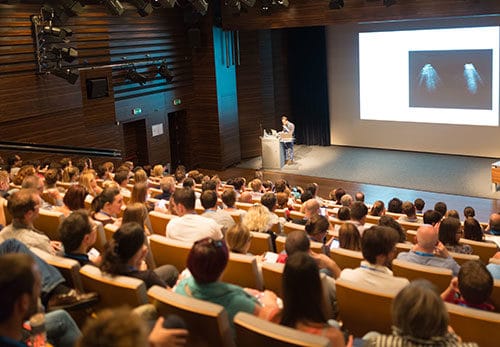 Presenter speaking in lecture hall