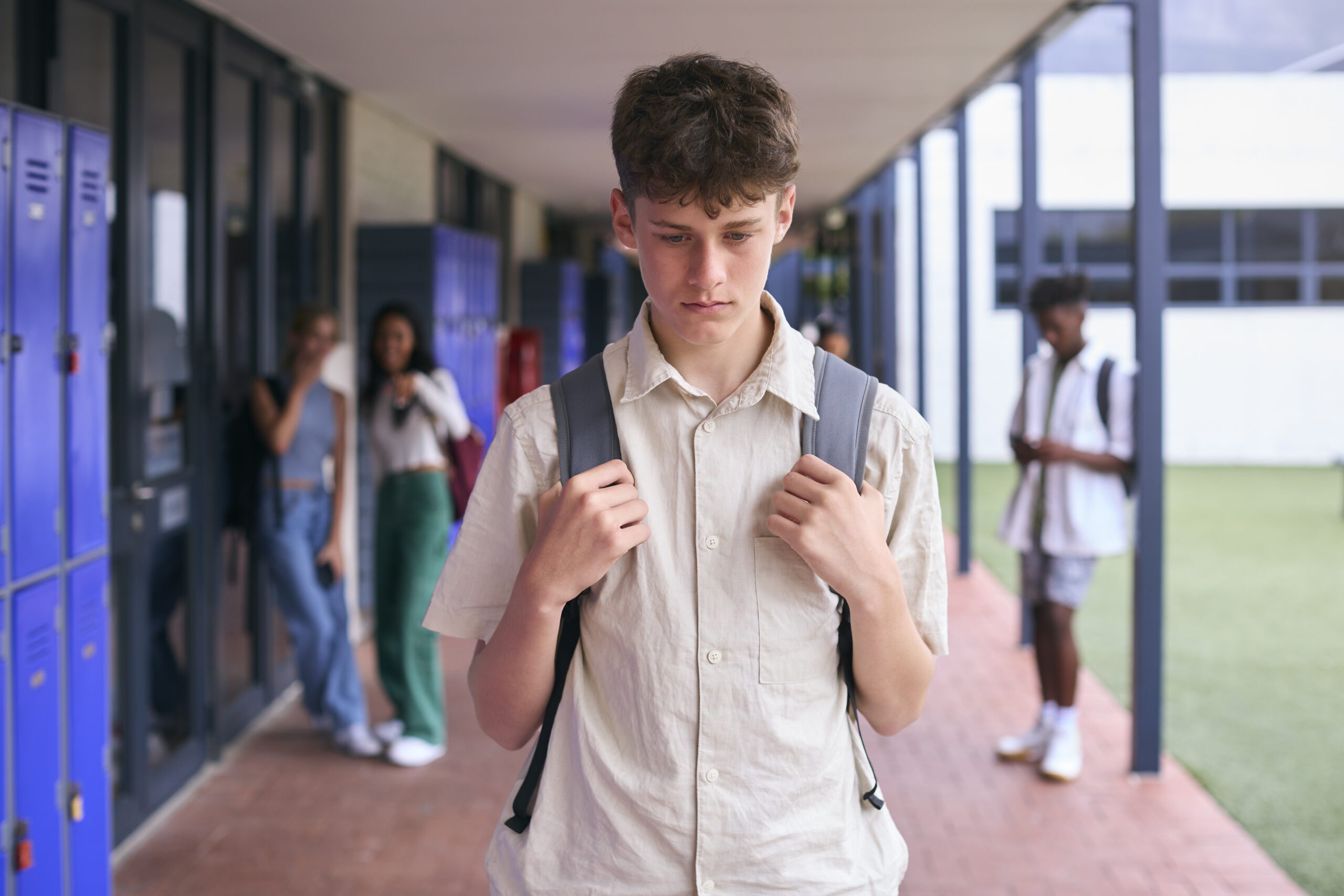 A teenage boy at school with his head down looking sad for the topic backtoschool anxiety.