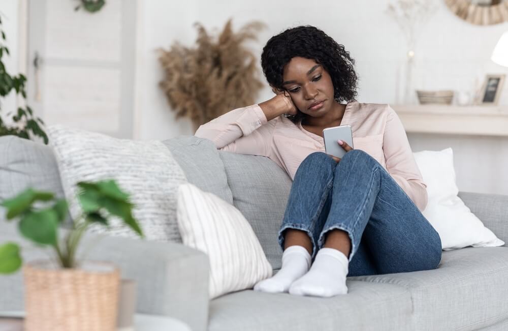 Woman with unhealthy emotional attachment looking at phone