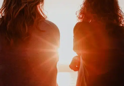 Women talk together about mental health and wellbeing while watching sunrise.