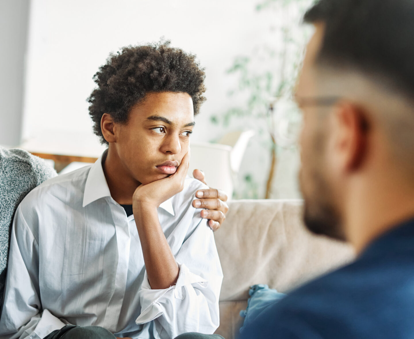 Young adult sitting with a parent during a supportive conversation at home