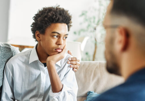 Young adult sitting with a parent during a supportive conversation at home